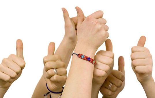 Group of hands giving thumbs up.