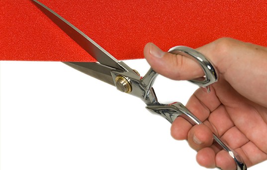 Hand cutting red ribbon