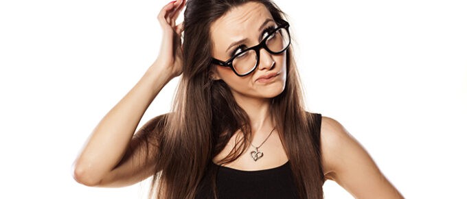 A young woman scratching her head, thinking