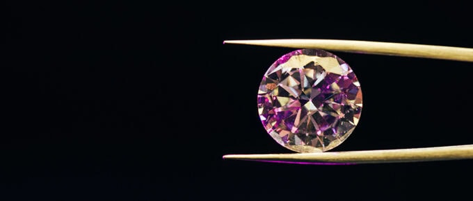 A beautiful gemstone held by tweezers, illustratinng quality content