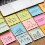 desk of an entrepreneur using sticky notes to plan business growth