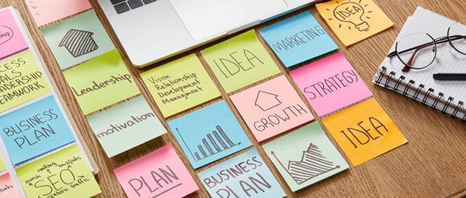 desk of an entrepreneur using sticky notes to plan business growth