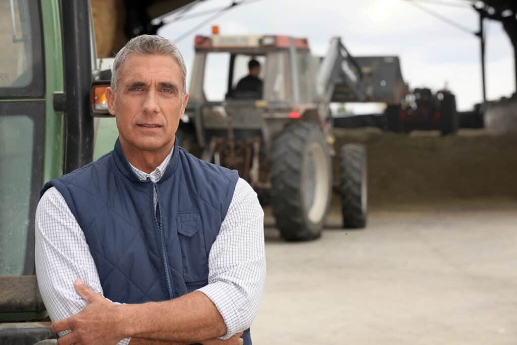 large equipment dealer standing beside a tractor